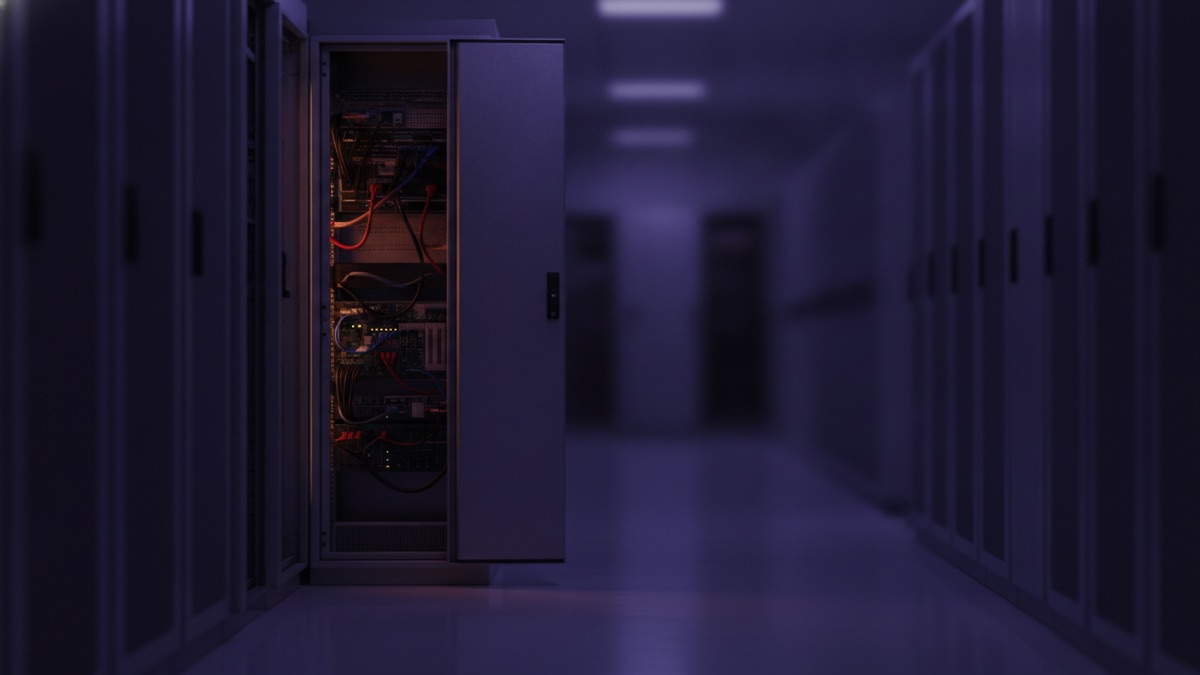 A server cabinet standing ajar in a dark data center aisle